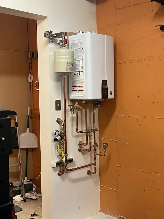 Plumbing technician inspecting water heater connections in Skippack